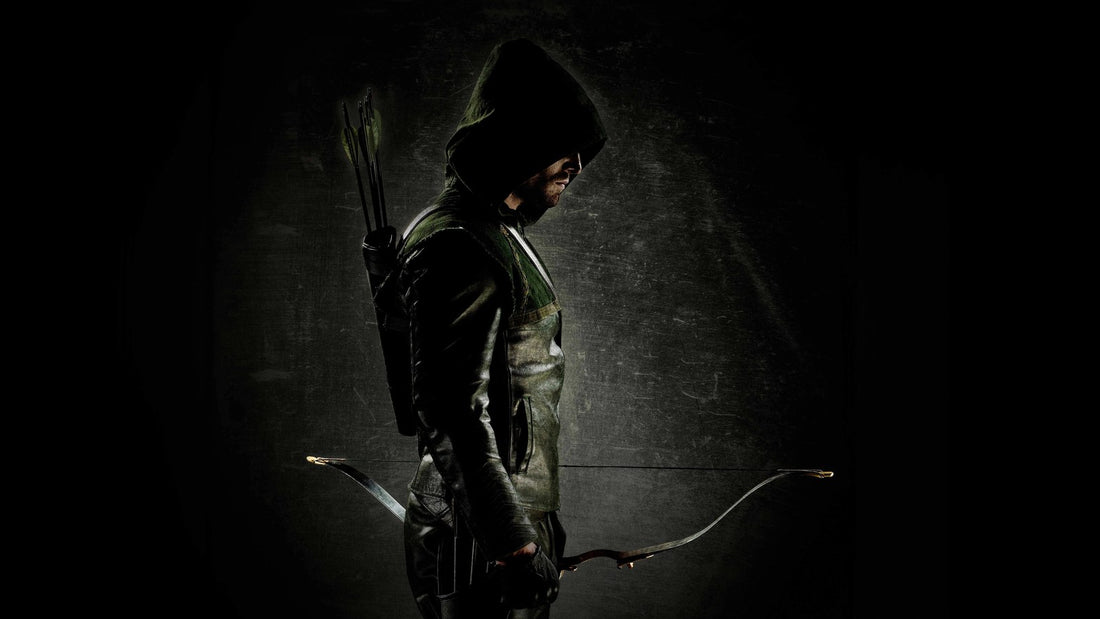 Stephen Amell en Green Arrow, capuche et arc, dans la série Arrow
