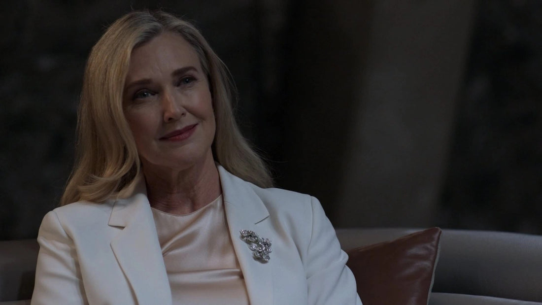 Brenda Strong en Lillian Luthor, tailleur blanc et broche, dans la série Supergirl
