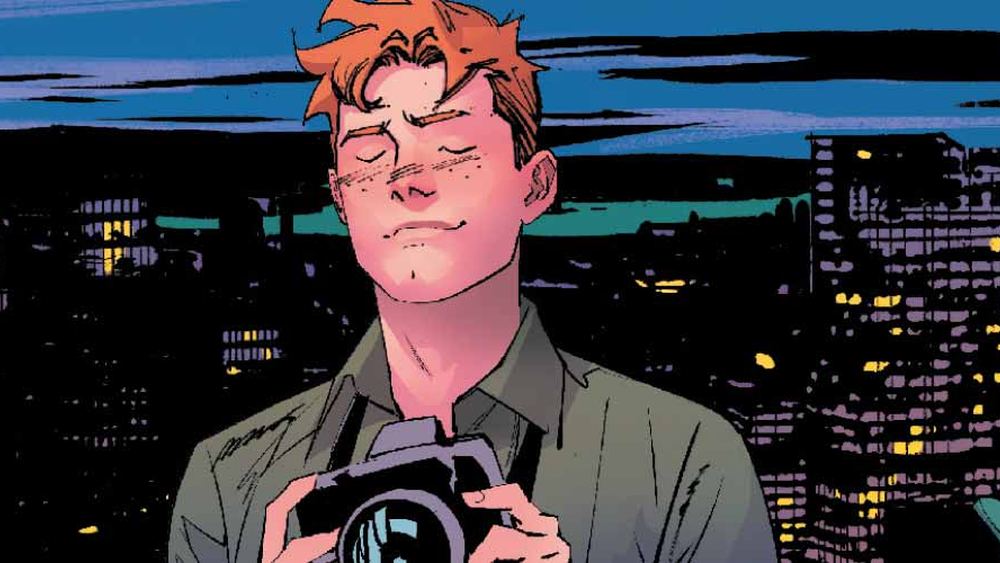 Jimmy Olsen, appareil photo en main, devant les lumières de Metropolis la nuit