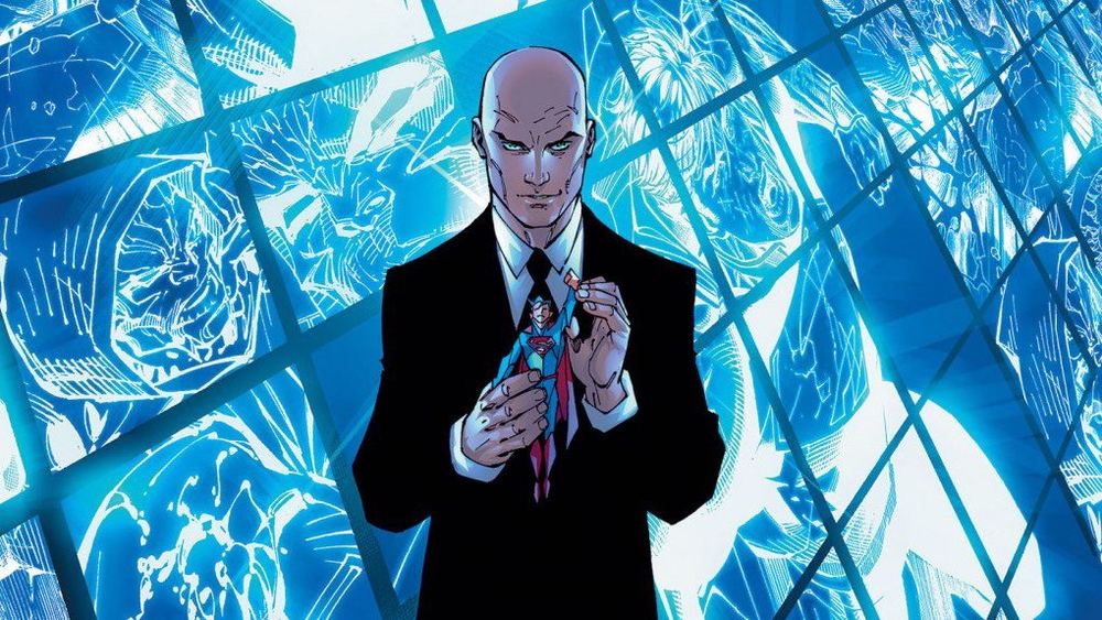 Lex Luthor en costume sombre devant une paroi de verre bleue