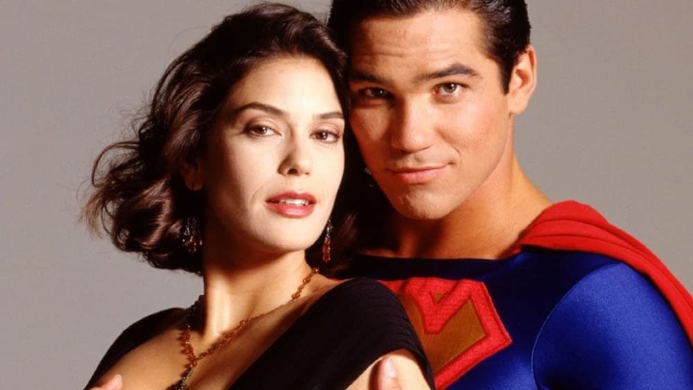 Teri Hatcher en Lois Lane, robe noire, Dean Cain en Superman derrière elle